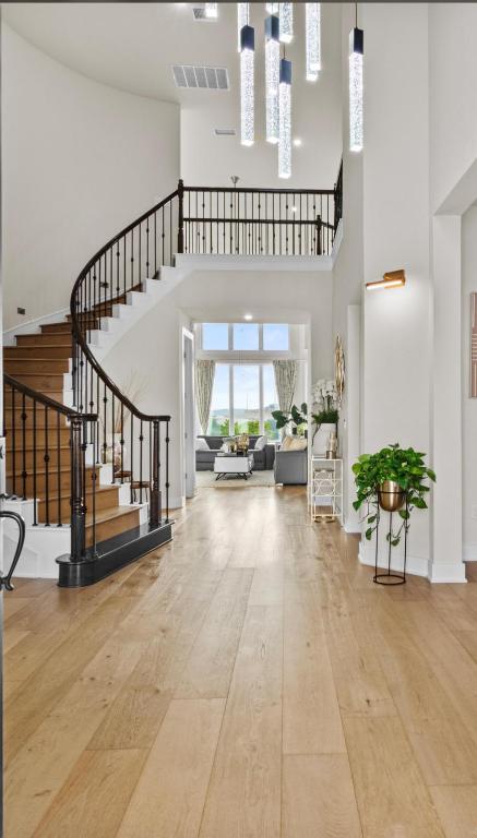 foyer with visible vents, baseboards, stairway, and hardwood / wood-style flooring