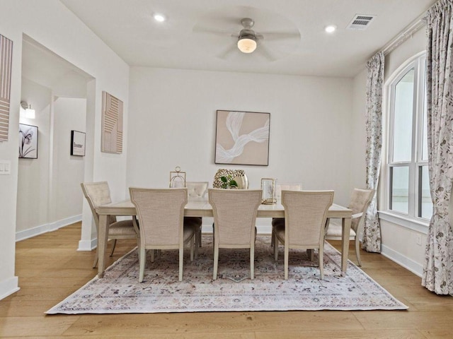 dining area with plenty of natural light, wood finished floors, visible vents, and baseboards