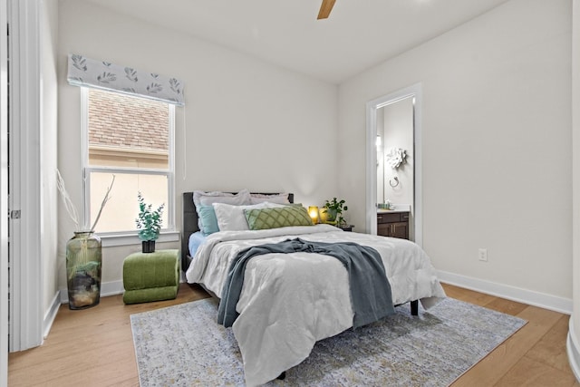 bedroom featuring a ceiling fan, baseboards, light wood-type flooring, and ensuite bathroom