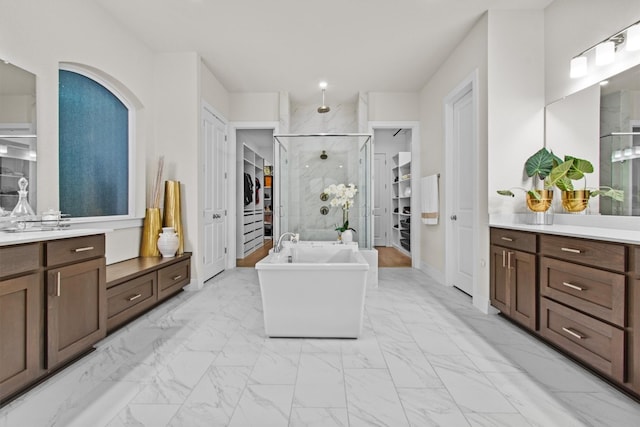 full bath with a shower stall, a freestanding tub, a spacious closet, and marble finish floor