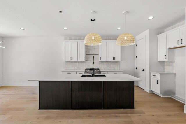 kitchen with decorative backsplash, light wood-style flooring, and light countertops