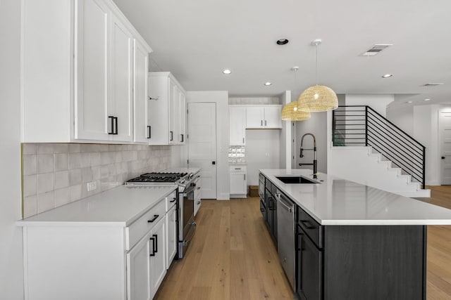 kitchen featuring a sink, visible vents, white cabinetry, light countertops, and appliances with stainless steel finishes