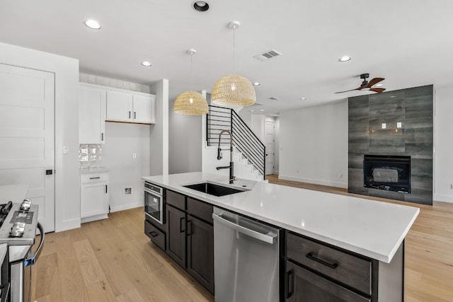 kitchen featuring white cabinetry, light countertops, appliances with stainless steel finishes, and a sink