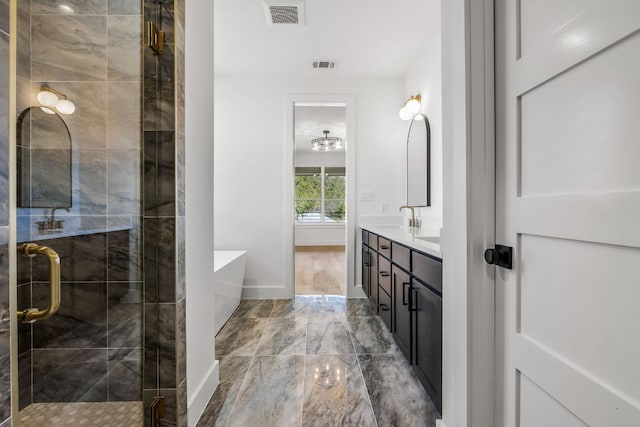 bathroom featuring visible vents, a shower stall, a freestanding bath, and vanity