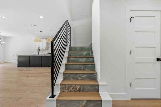 stairway featuring recessed lighting, visible vents, wood finished floors, and baseboards