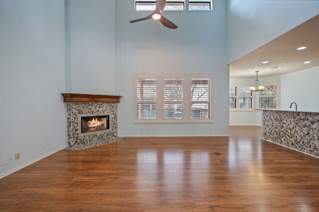 4229 Johns Light Dr, Austin, TX 78727 - unfurnished living room with ceiling fan, wood finished floors, a high end fireplace, a chandelier, and a high ceiling