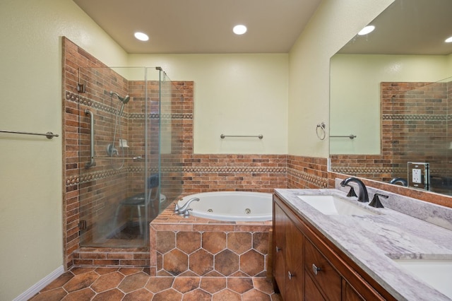 full bath featuring a sink, a jetted tub, a shower stall, and tile patterned floors