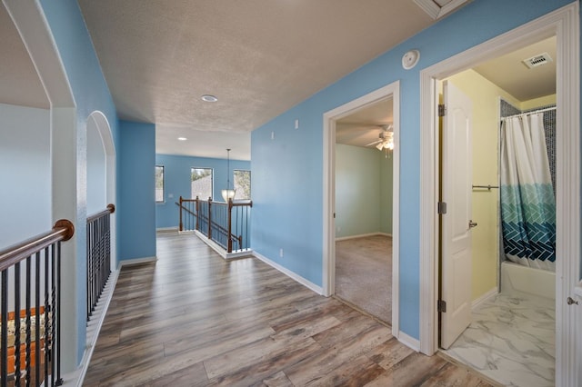 4229 Johns Light Dr, Austin, TX 78727 - hall with an upstairs landing, baseboards, wood finished floors, a textured ceiling, and recessed lighting