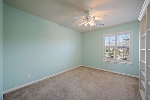 spare room with visible vents, carpet floors, baseboards, and a ceiling fan