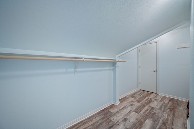 spacious closet featuring vaulted ceiling and wood finished floors