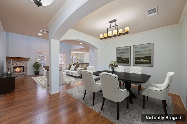 dining room featuring ornamental molding, dark wood-style floors, visible vents, and a chandelier