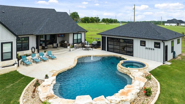 view of swimming pool featuring a yard, a patio area, a pool with connected hot tub, and an outdoor hangout area