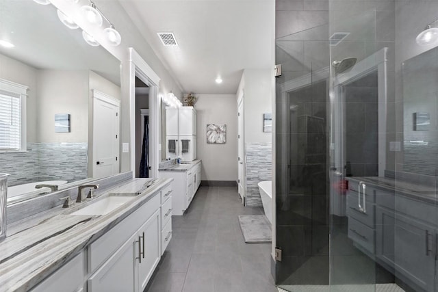 bathroom with visible vents, two vanities, a stall shower, a sink, and tile patterned floors