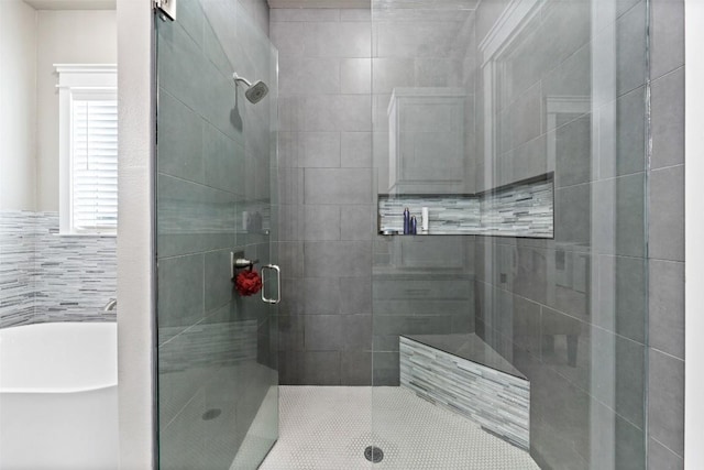 full bathroom with a freestanding tub and a stall shower