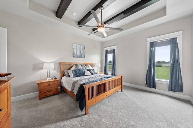 bedroom with beam ceiling, a ceiling fan, a tray ceiling, carpet, and baseboards