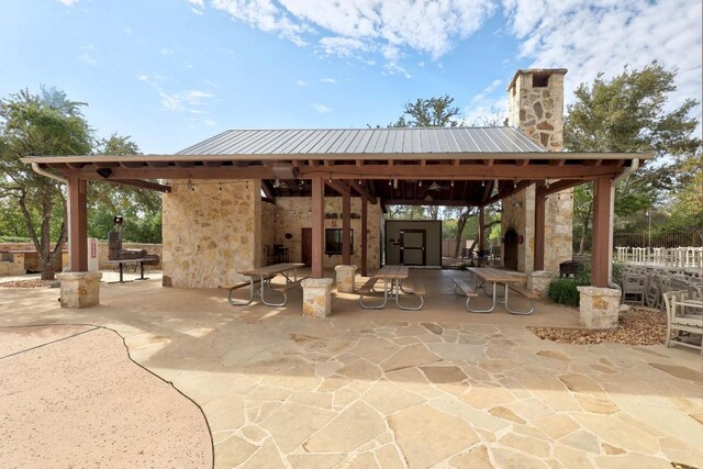 view of patio featuring a gazebo, a fireplace, and an outdoor structure