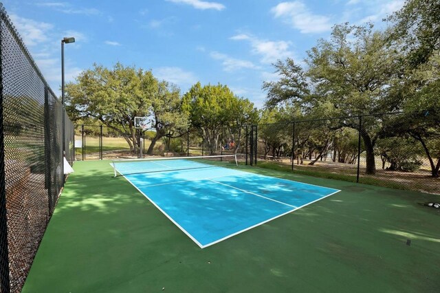 view of tennis court featuring fence