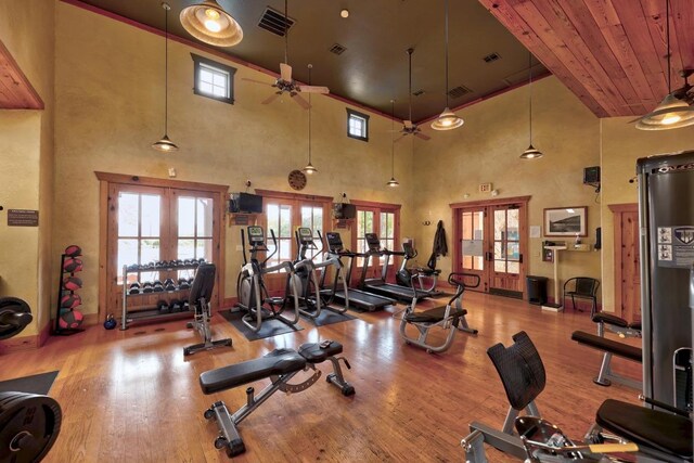 gym featuring ceiling fan, french doors, visible vents, and wood finished floors