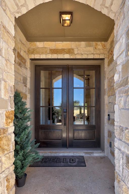 doorway to property featuring stone siding and french doors