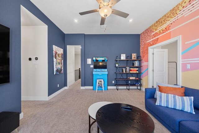 living area featuring carpet flooring, a ceiling fan, and baseboards