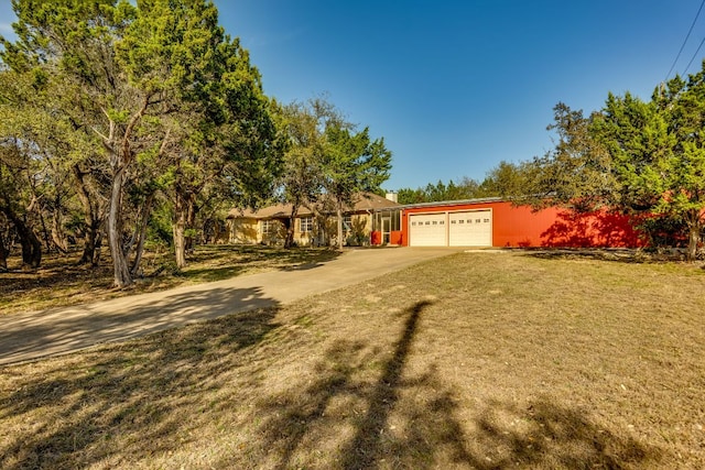 ranch-style home featuring an attached garage, concrete driveway, and a front yard