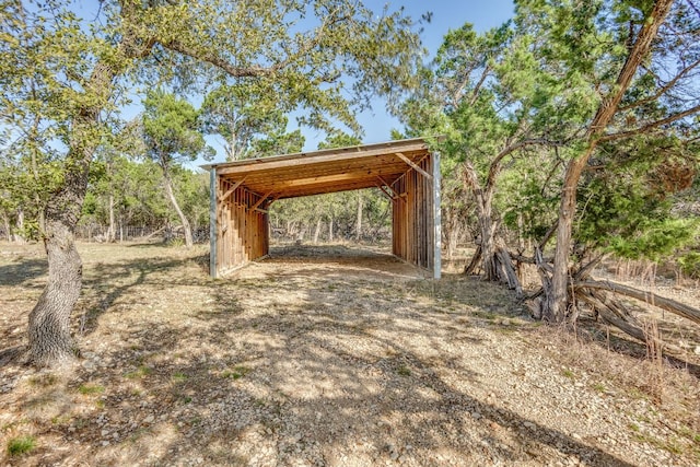 view of yard featuring a carport, driveway, and an outdoor structure