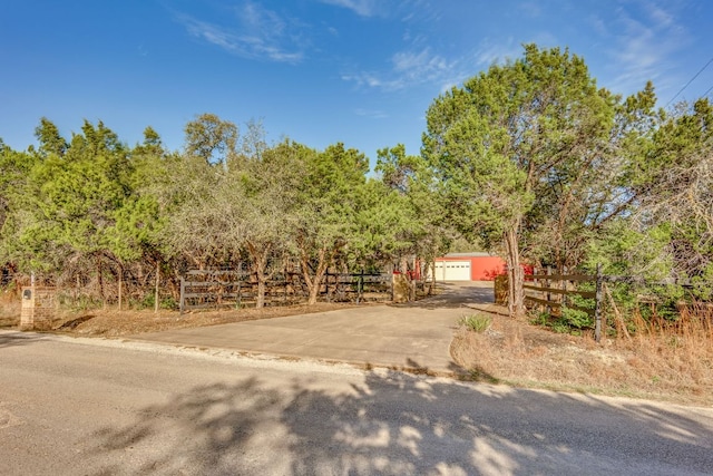 view of front of property with a detached garage and fence