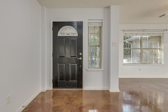 entrance foyer featuring visible vents, finished concrete flooring, and baseboards