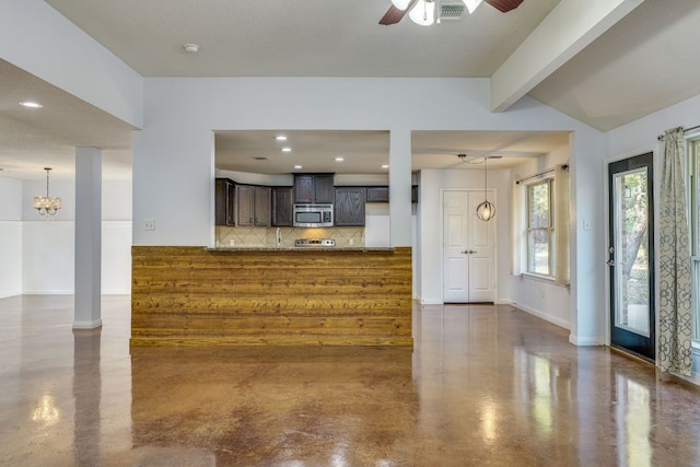 kitchen with stainless steel microwave, visible vents, tasteful backsplash, and concrete flooring