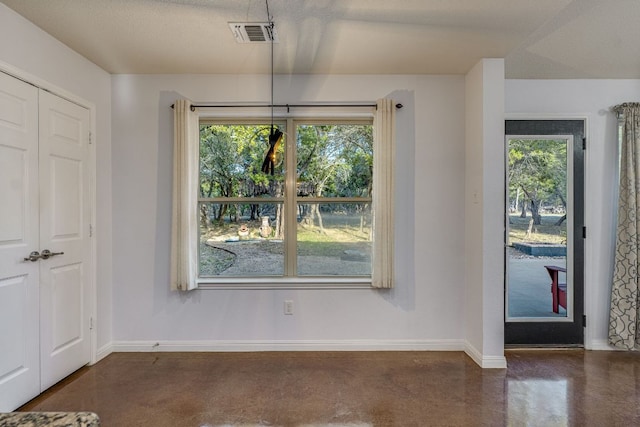 unfurnished dining area featuring visible vents, a healthy amount of sunlight, concrete floors, and baseboards