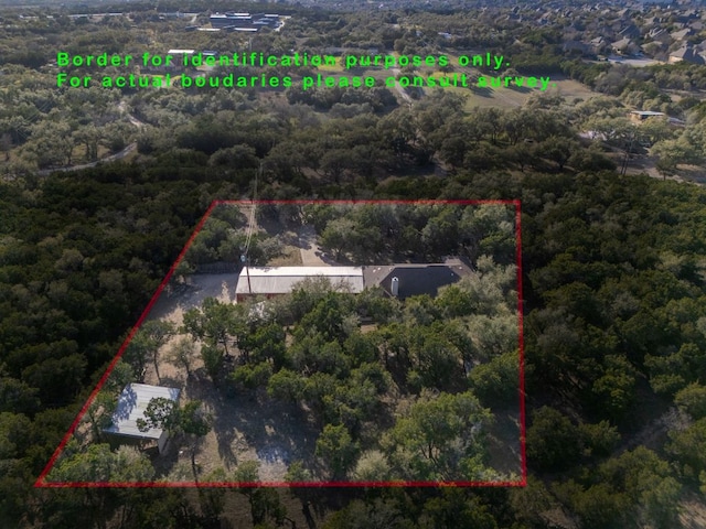 birds eye view of property with a wooded view