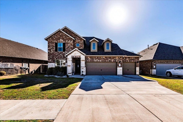 traditional home featuring brick siding, an attached garage, a front lawn, stone siding, and driveway