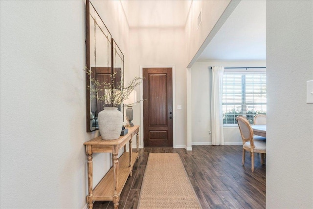 entryway with dark wood-style floors, visible vents, and baseboards