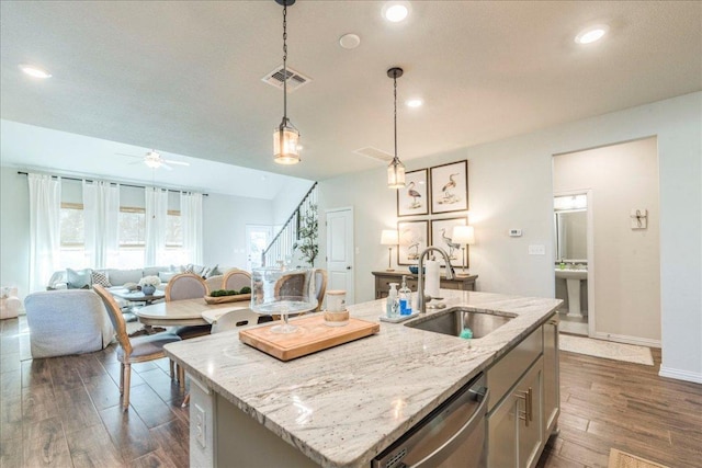 kitchen featuring visible vents, a sink, dark wood finished floors, dishwasher, and hanging light fixtures