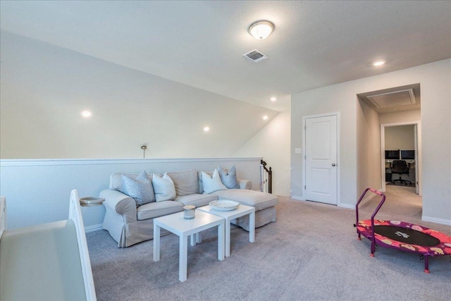 carpeted living area featuring visible vents, attic access, and baseboards