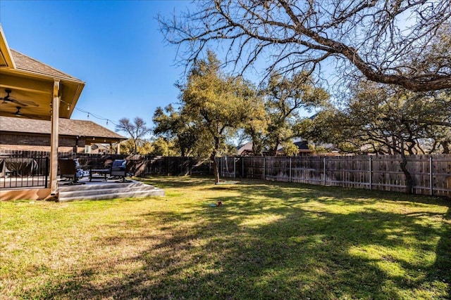 view of yard featuring a patio area, a ceiling fan, and a fenced backyard