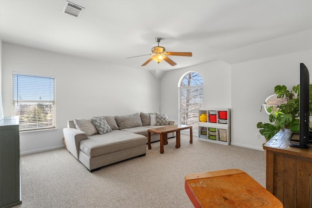 living area with visible vents, light colored carpet, a ceiling fan, and baseboards