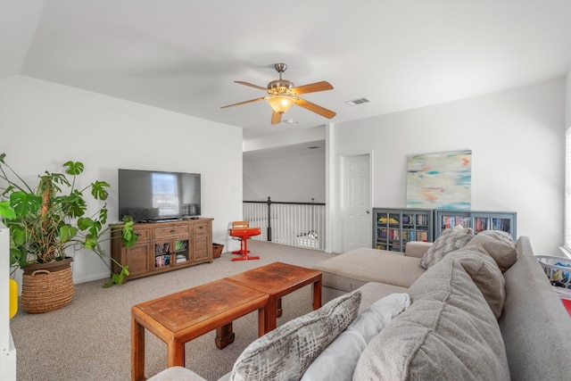 living area featuring ceiling fan, visible vents, and light carpet