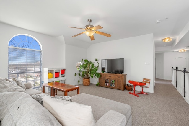 carpeted living area featuring a ceiling fan and vaulted ceiling