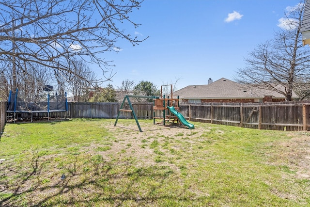 view of yard featuring a fenced backyard, a playground, and a trampoline