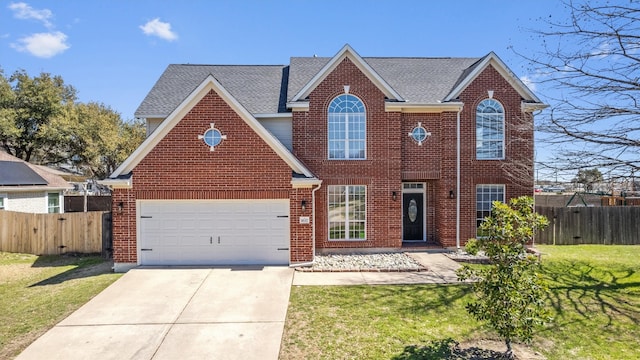 traditional-style house featuring fence, driveway, an attached garage, a front lawn, and brick siding