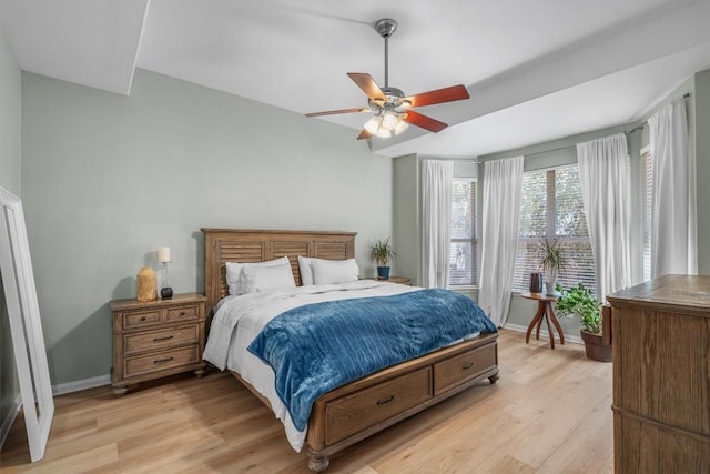 bedroom with baseboards, a ceiling fan, and light wood finished floors