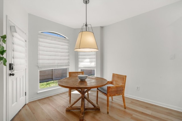 dining space with light wood-style floors, baseboards, and breakfast area