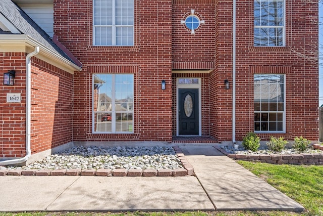 doorway to property with brick siding