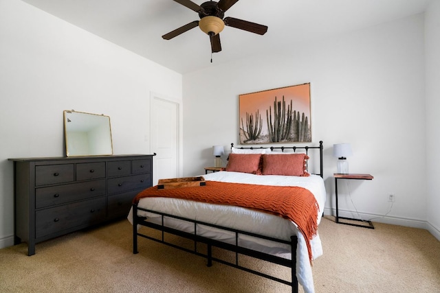 bedroom with light colored carpet, baseboards, and ceiling fan