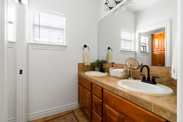 bathroom featuring double vanity, a healthy amount of sunlight, and a sink