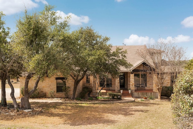 view of front of property featuring stone siding and covered porch