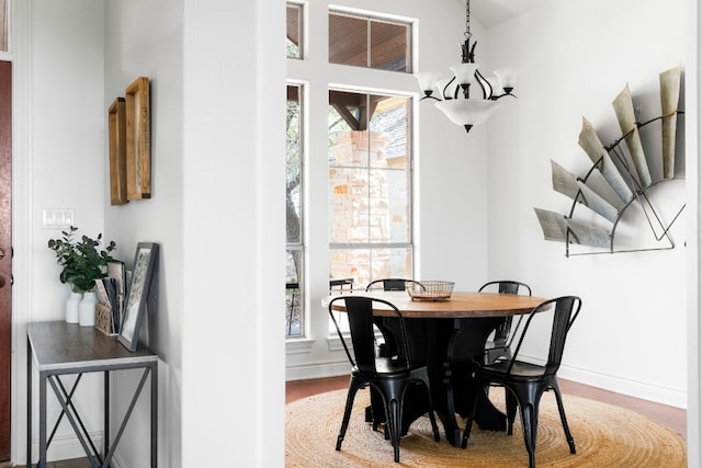 dining room with a chandelier, baseboards, and wood finished floors