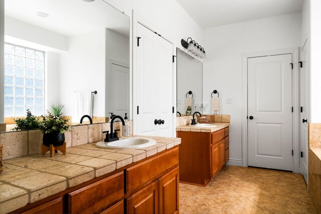 bathroom featuring a sink and two vanities