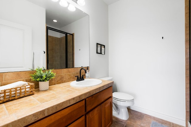 bathroom with vanity, a shower stall, toilet, and backsplash